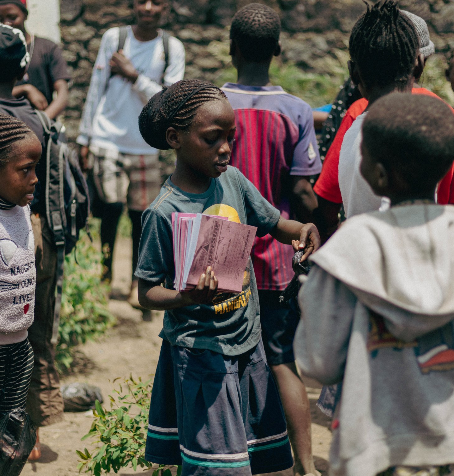 A young person holding school materials at Tumaini Cycling Academy